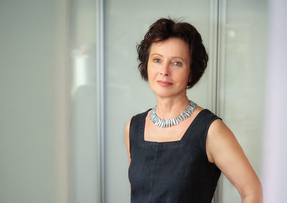 Hilde Kuch-Kuthe schaut her. Sie steht vor einem geschlossenem, weißen Büroschrank.